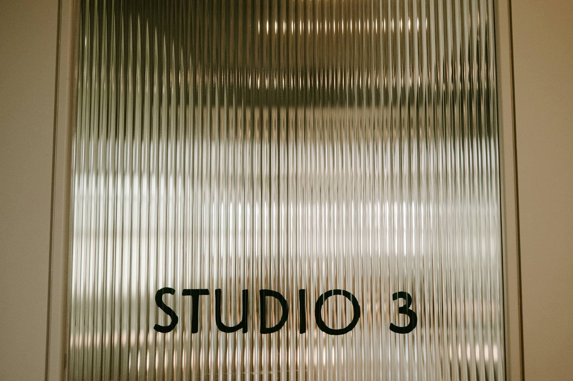 Porte de studio en verre cannelé portant l'inscription « Studio 3 »